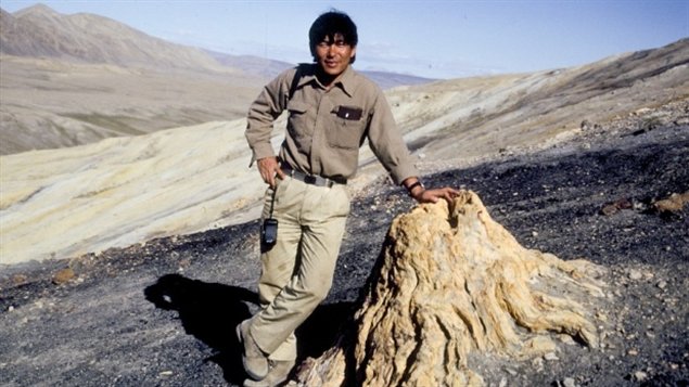  Dr. Tatsuo Sweda, de l'université de Nagoya au Japon  devant un tronc fossilisé près du Fjord Strathcona sur l'île d'Ellesmere au Nunavut en 1990.
